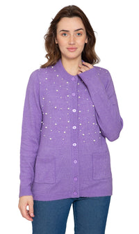 A woman wearing a purple cardigan with faux pearl accents on the front and pearl buttons. The cardigan has a crew neck and two front patch pockets.