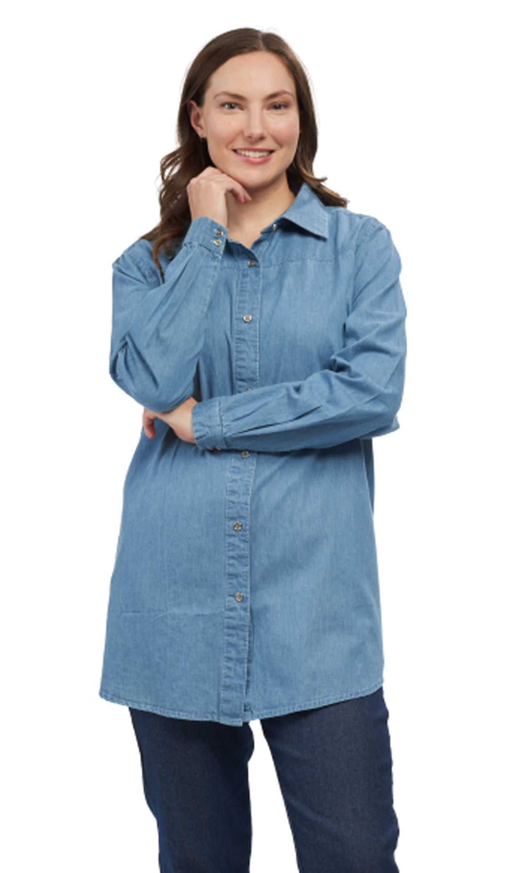 A woman wearing a long sleeve denim tunic top with a collar, button cuffs, and a shirttail hem.